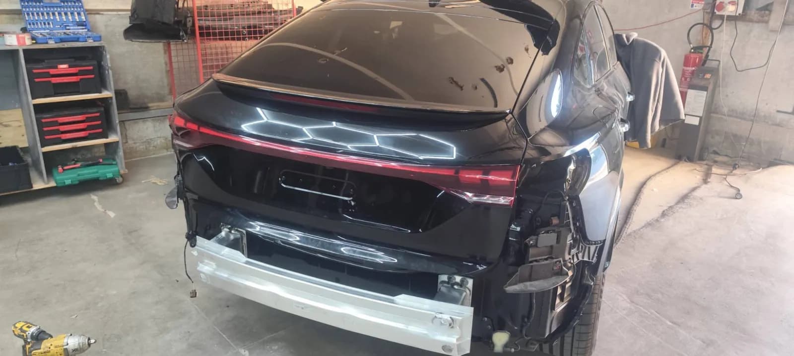 Audi Q6 noire avec son hayon en place, pare-chocs arrière pas encore remonté
